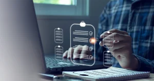 A person using a laptop and a digital checklist overlay to prepare for an ISO surveillance audit in UAE, representing quality management and compliance standards.