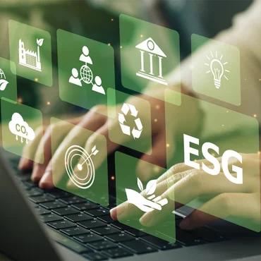 A professional typing on a laptop overlaid with digital icons for sustainability, social responsibility, and governance, representing ESG Reporting in UAE standards.
