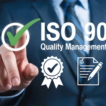 A professional in a suit pointing to a digital ISO 9001 Quality Management System interface with icons for certification, documentation, and processes, representing the transition to the ISO 9001:2026 Revision.